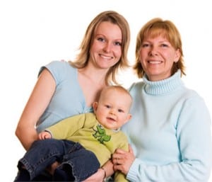 Picture of two smiling women, one holding a baby Picture of two smiling women, one holding a baby